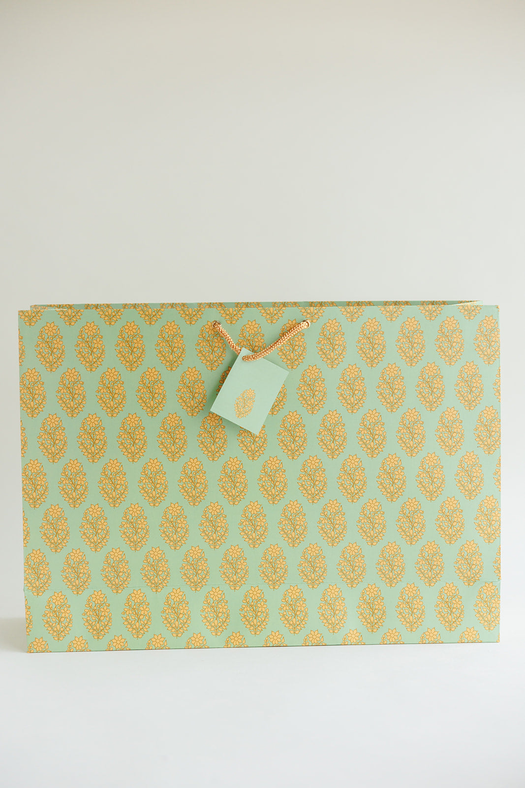 large green gift bag with tags